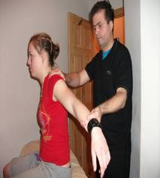 Young lady having Sports Massage treatment in Cardiff clinic for sports injury pain in shoulder and neck pain